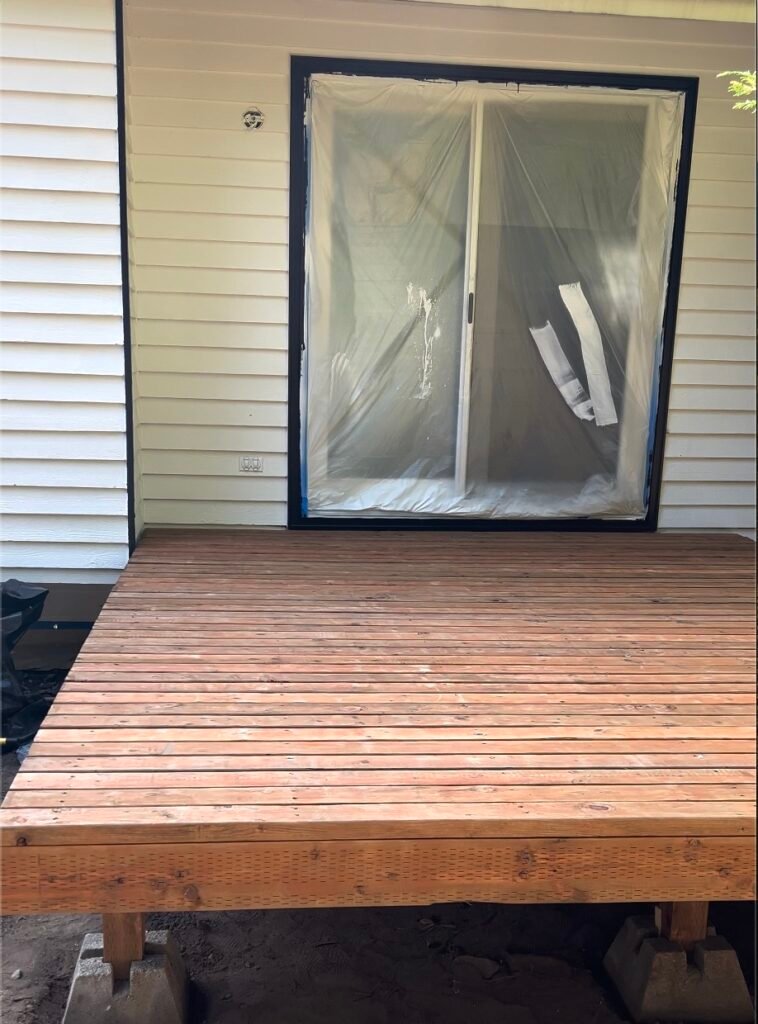New cedar deck built on posts behind a white house in Washington by Inreal Construction