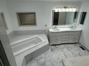 Finished master bathroom with marble tile, soaking tub and custom double-sink vanity with LED mirrors