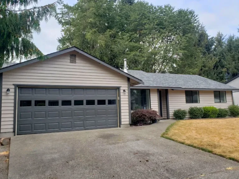 After: repainted grey rambler with new garage door and clean gutters