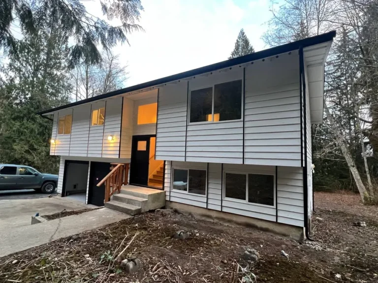 After: same home with new white siding, fascia and gutters