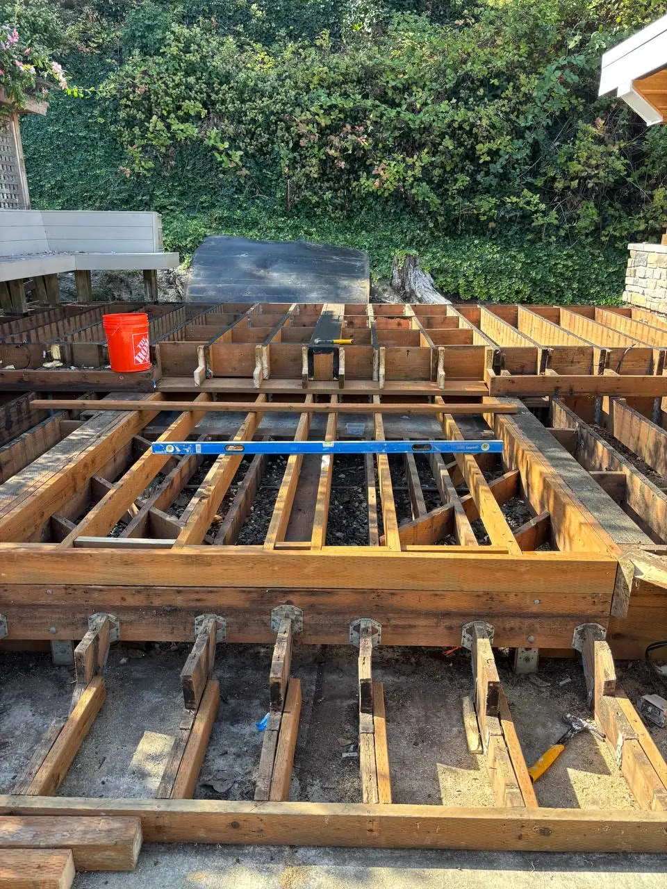 Deck framing repair: new joists and beams checked with a level